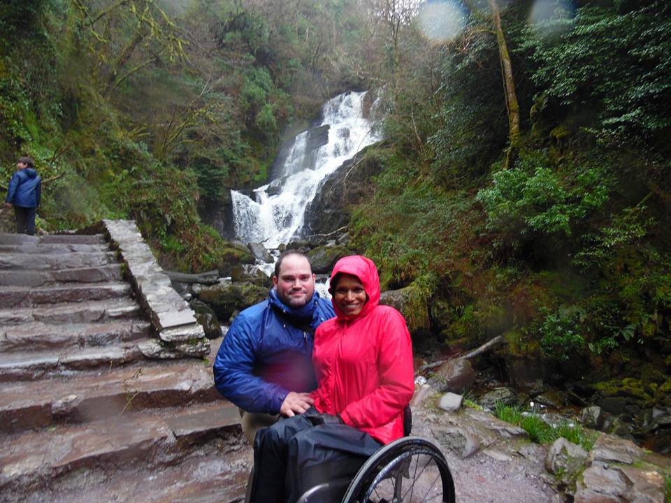 Maggie and Abe by rock steps in front of a waterfall.