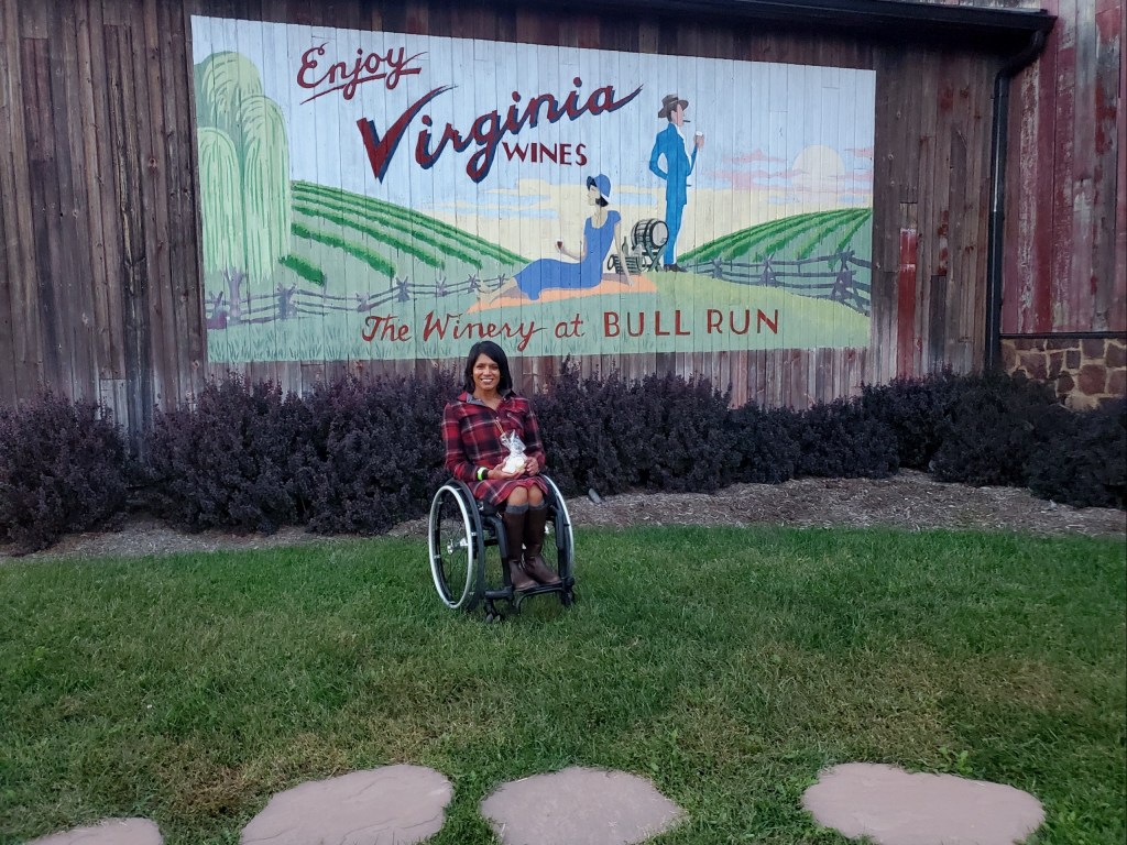 Maggie in front of an Enjoy Virginia Wines mural at The Winery at Bull Run